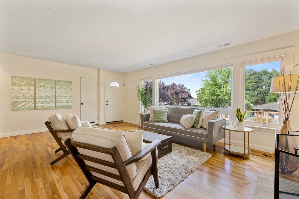 room with gray leather sofa, brown wooden side table, and armchairs