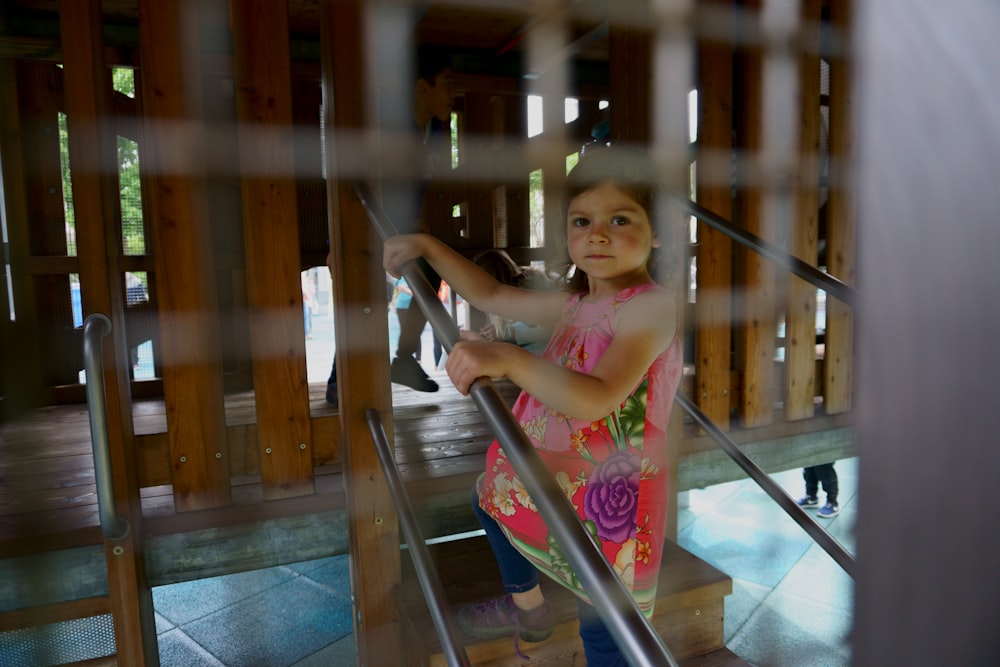 girl wearing pink dress holding black metal rod