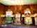 The image features three colorful, traditional Jagannath deities with large eyes, intricate patterns, and vibrant clothing. They are made of wood and embellished with beads and fabric, set against a textured brown background.