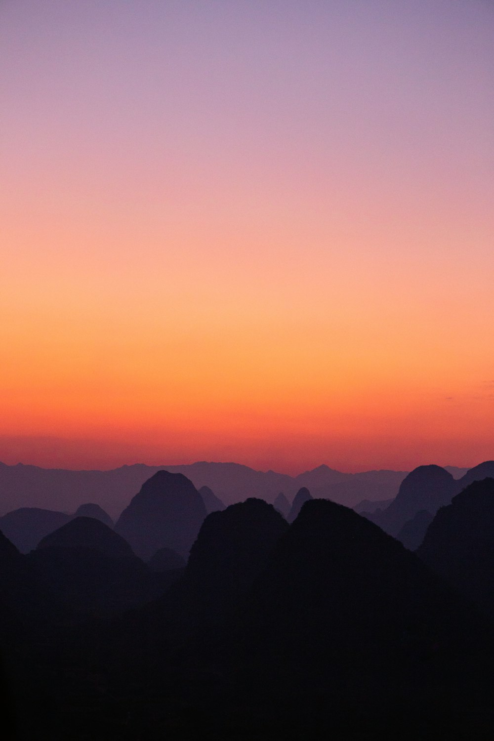 夜明けの山のシルエット写真