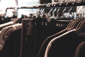 A pair of elegant black tailored pants hanging on a modern rack with soft lighting