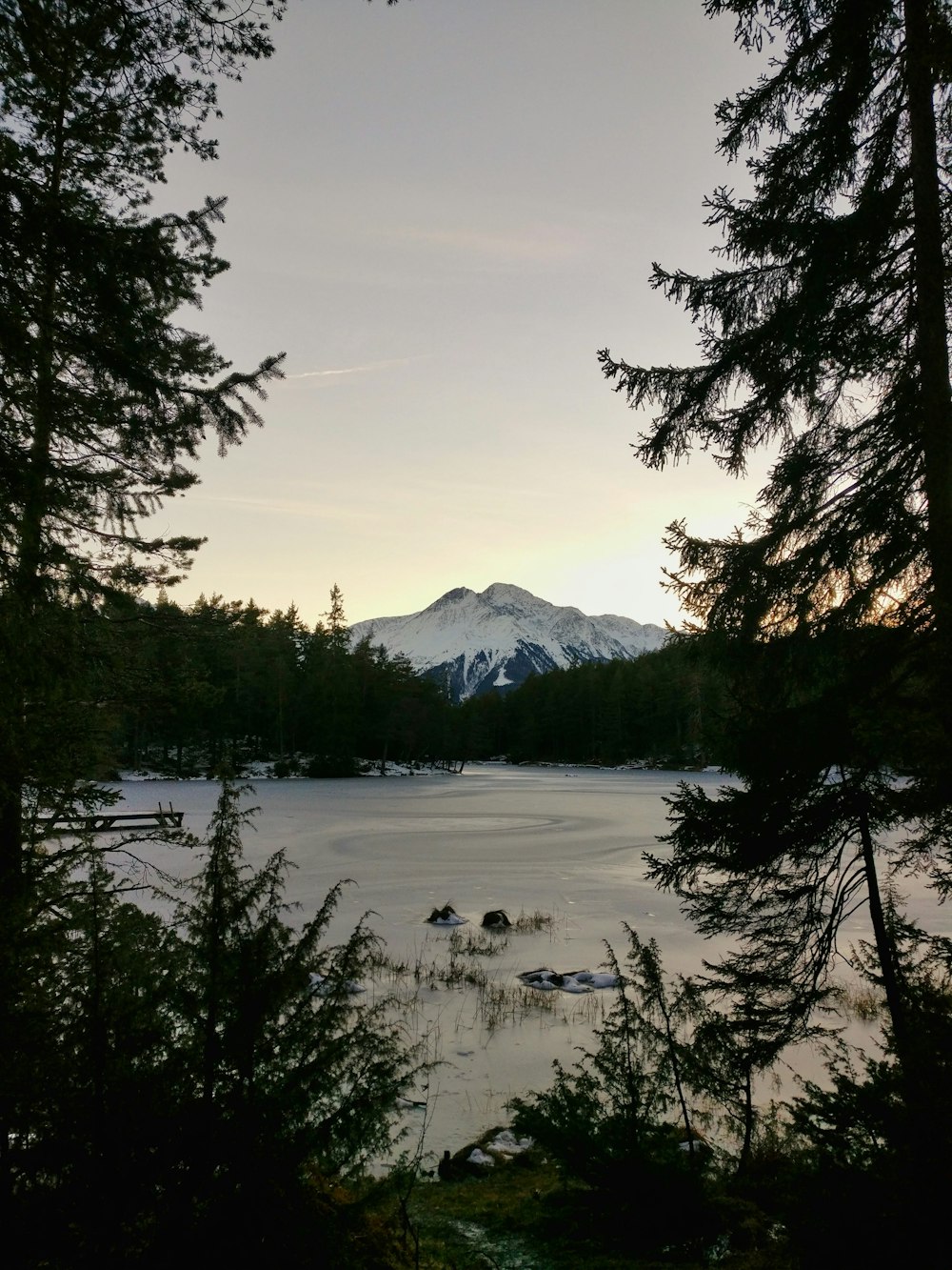 body of water near snow-covered mountain