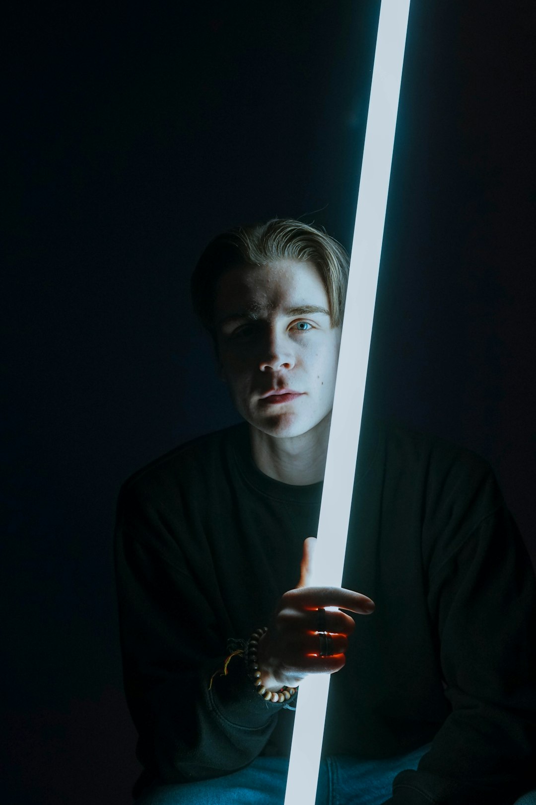 man holding lighted fluorescent lamp