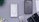 A collection of iPhones and accessories are displayed on a flat surface. The image features several iPhones in different colors, including black, yellow, and mulberry. There is an open phone box containing EarPods and a charging adapter. A box of an iPhone is positioned upright, and there's a small green plant in the corner.
