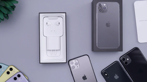 A selection of certified pre-owned iPhones displayed neatly on a modern black surface with orange accents.