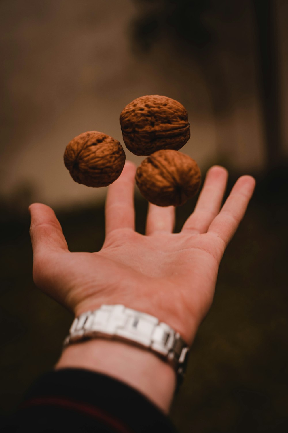person throwing three walnuts