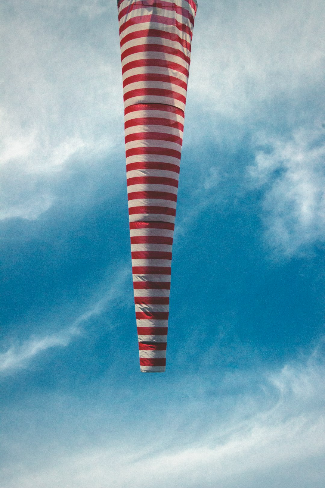 red and white striped hot air balloo under blue and white sky