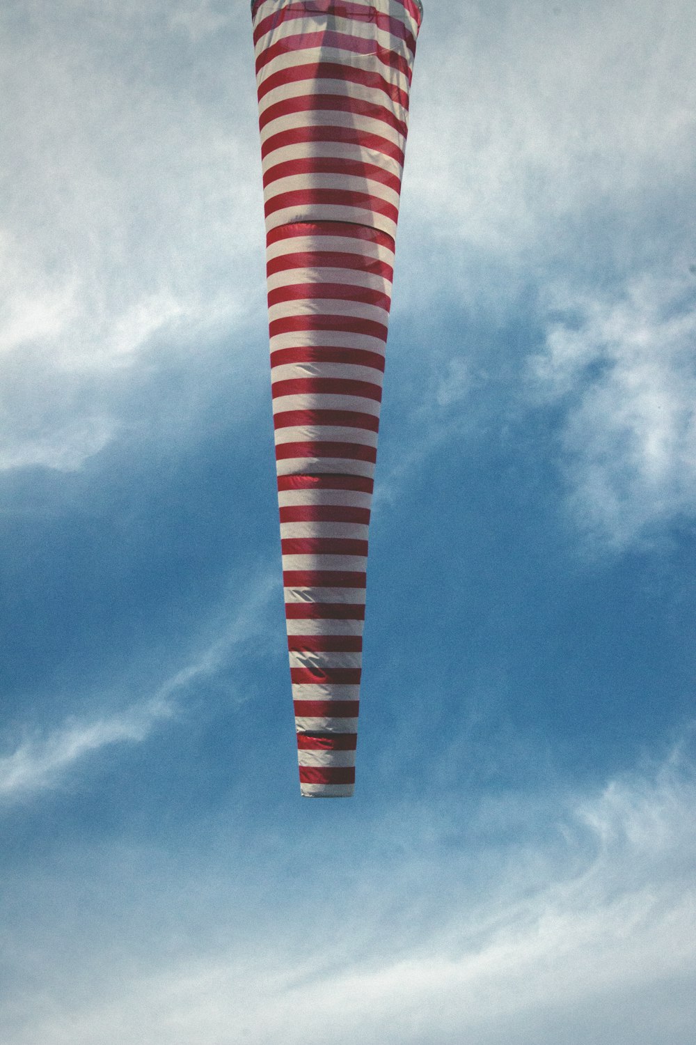 red and white striped hot air balloo under blue and white sky