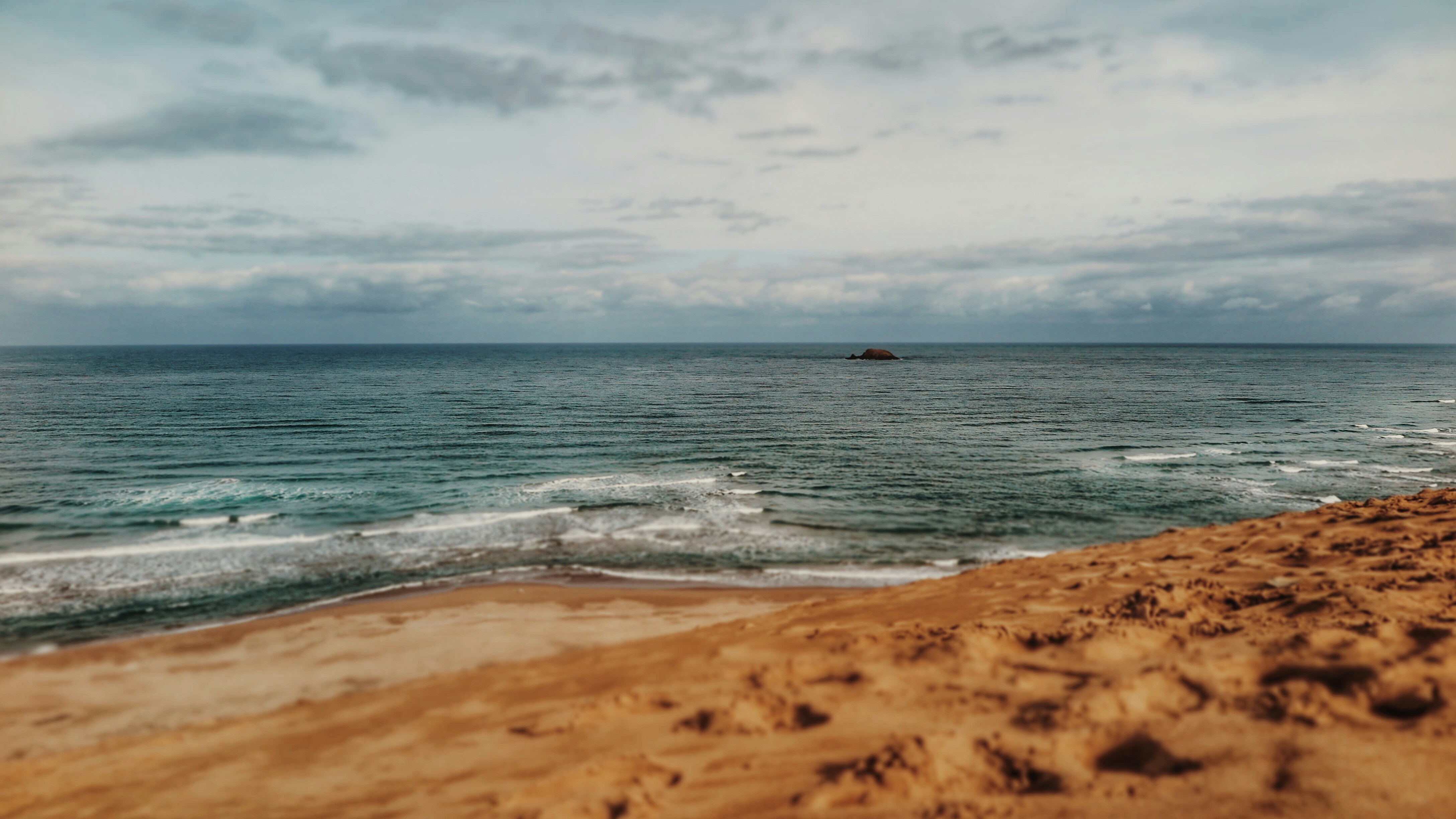 white sand and body of water