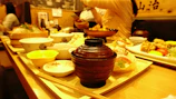 Friends laughing and enjoying Japanese dishes together in a modern, youthful restaurant setting.