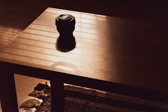 A minimalist 3D-printed coffee table with a textured surface made from recycled filaments, set on a soft rug.