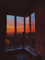 A vibrant cityscape at sunset viewed from an office window where news is being prepared.