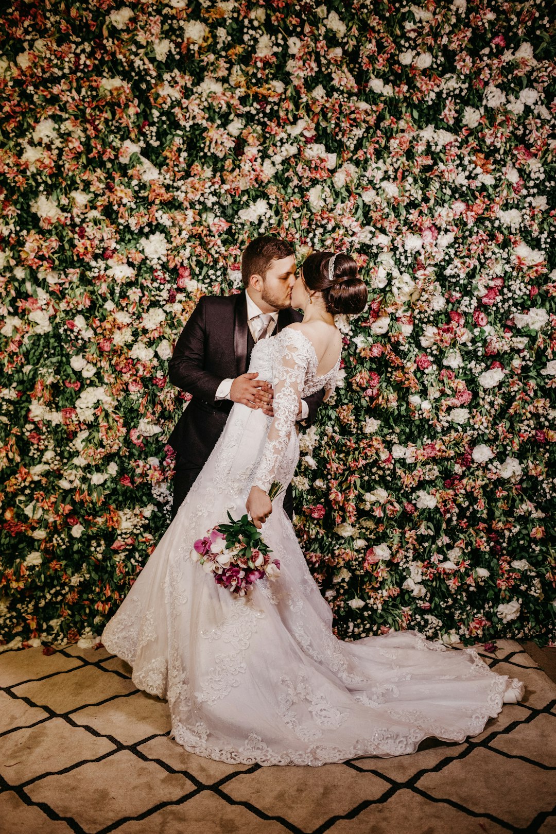 wedding couple kissing with red and white flowers background