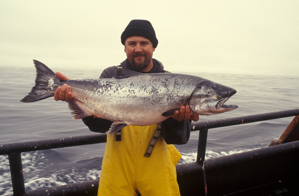 man carrying silver fish