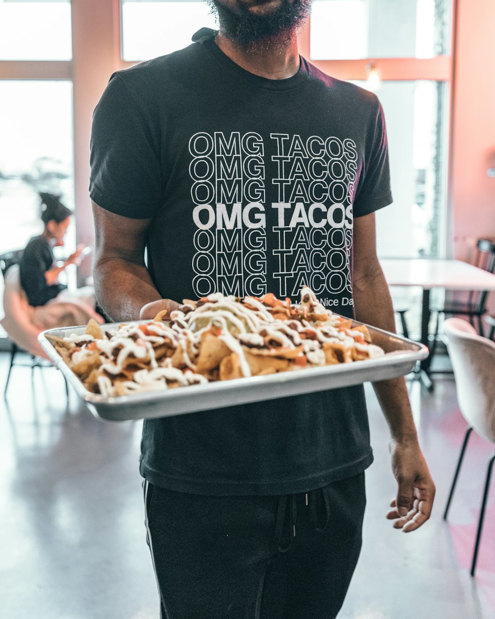 man holding tray of nachos