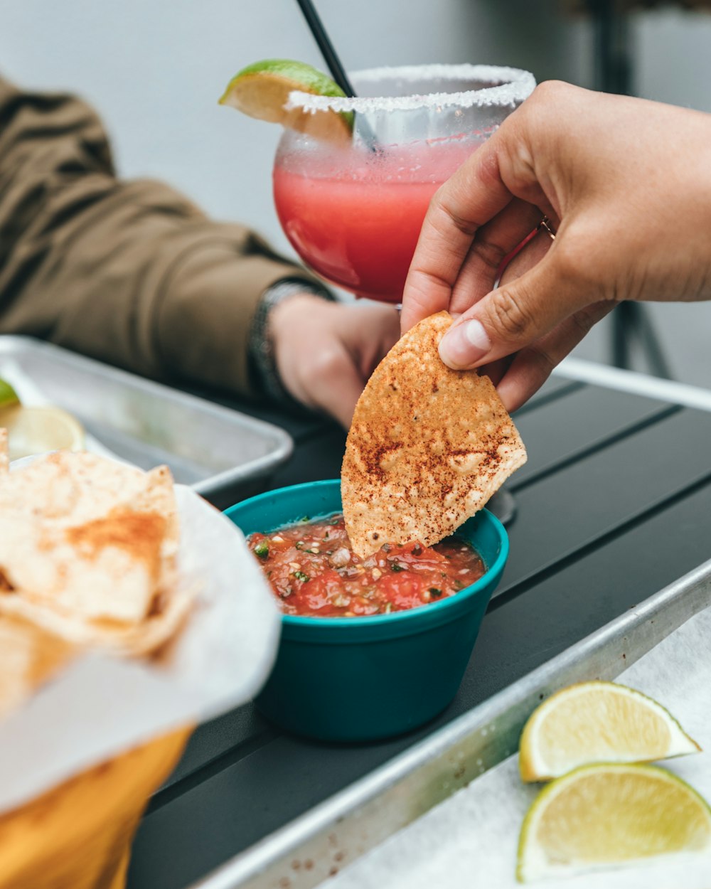 personne trempant des nachos sur de la sauce