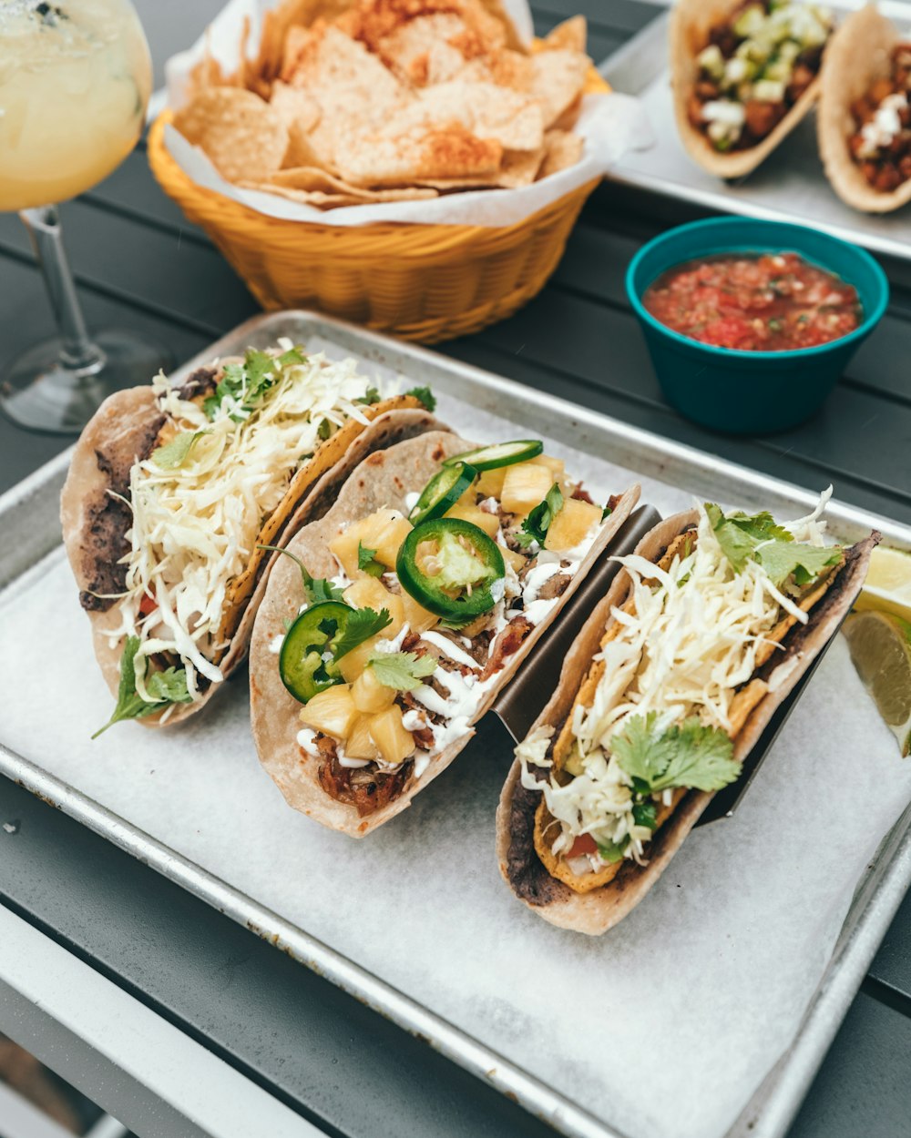 three fresh tacos on gray tray