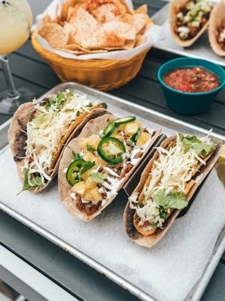 three fresh tacos on gray tray