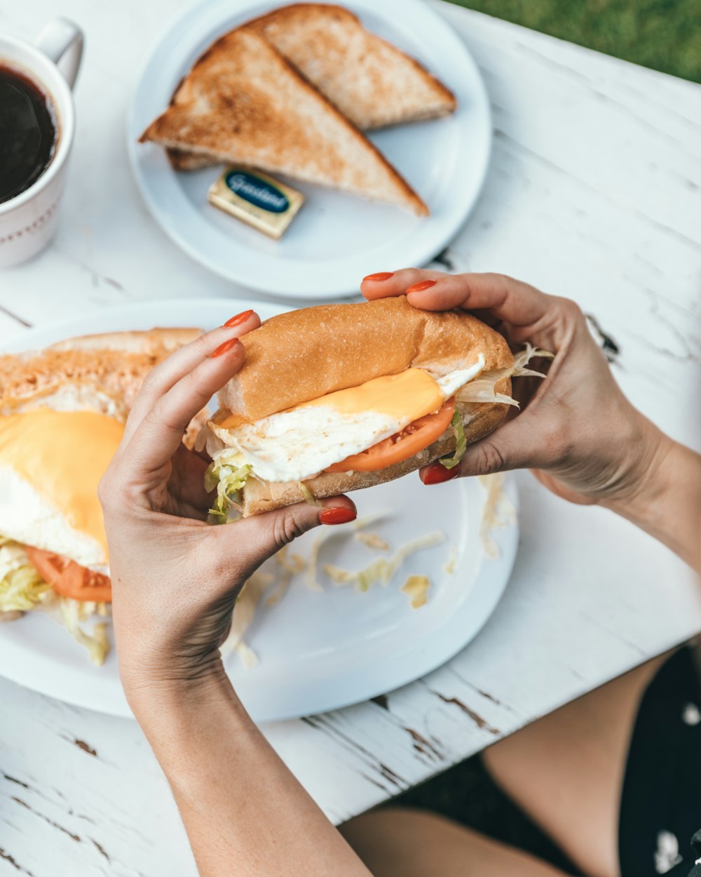 person holding burger with cheese