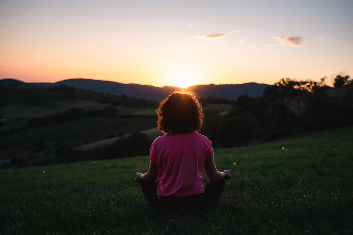 Woman meditating in golden hour light
