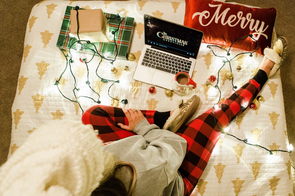 a person laying on a bed with a laptop