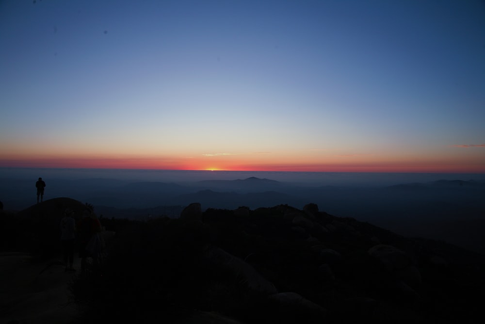 silhouette of person standing on cliff