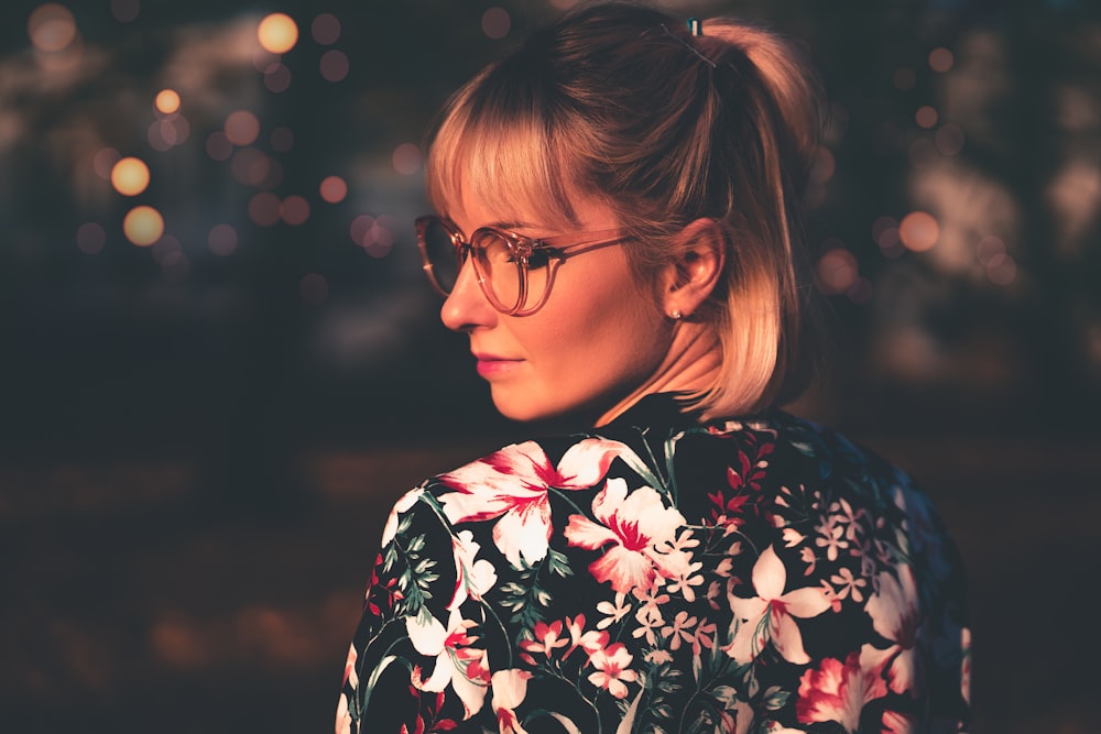 woman wearing multicolored floral top looking side