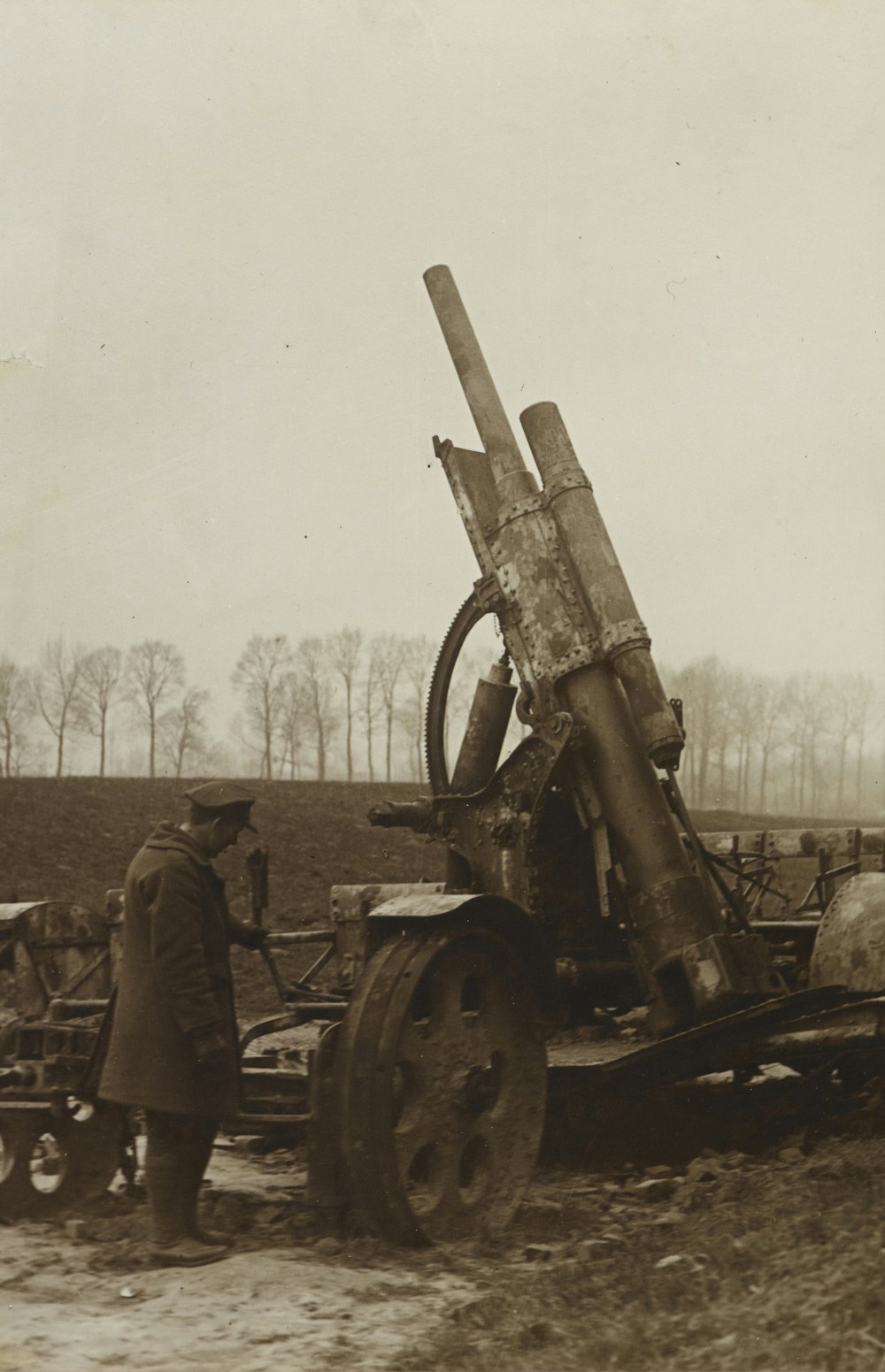 Hombre de pie junto a la artillería remolcada