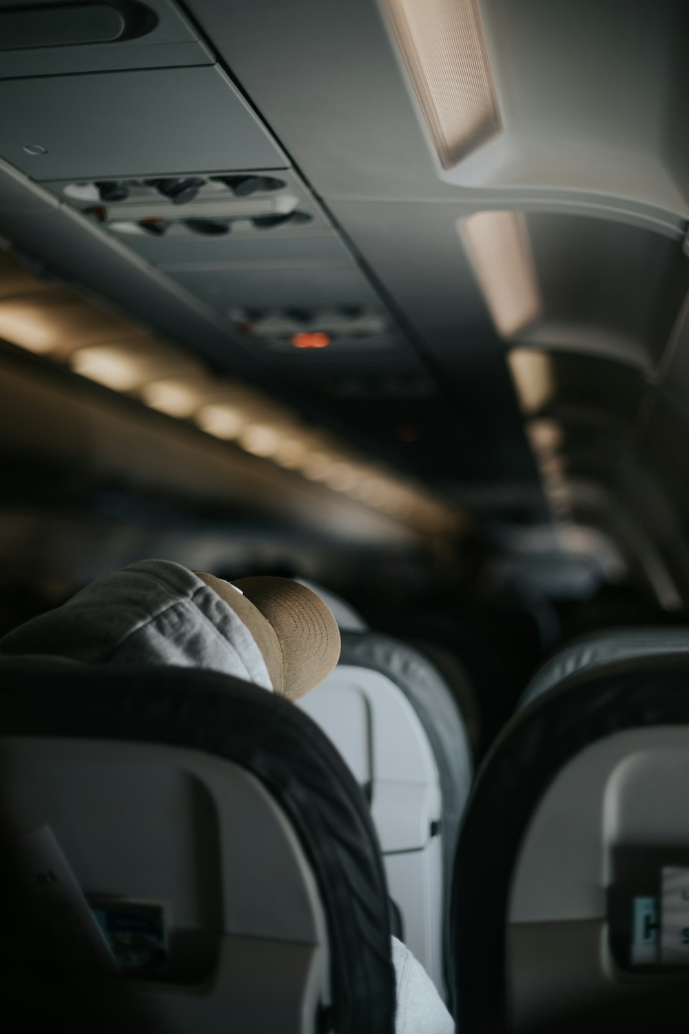 a person with a hat sitting in an airplane
