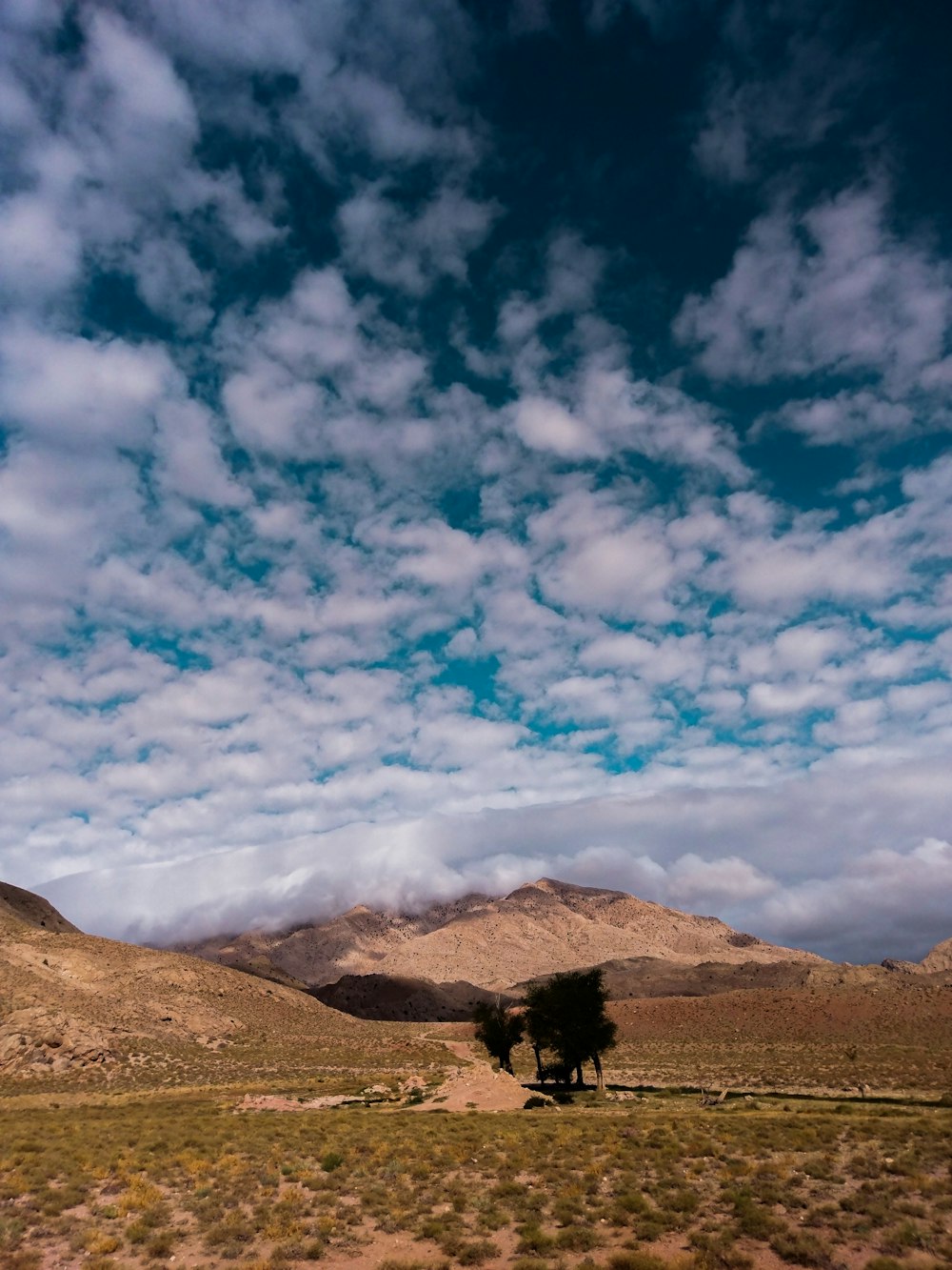 Montaña marrón bajo nubes blancas durante el día