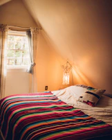 Cozy bedroom with soft linens and warm lighting inside Angin Timur Homestay.