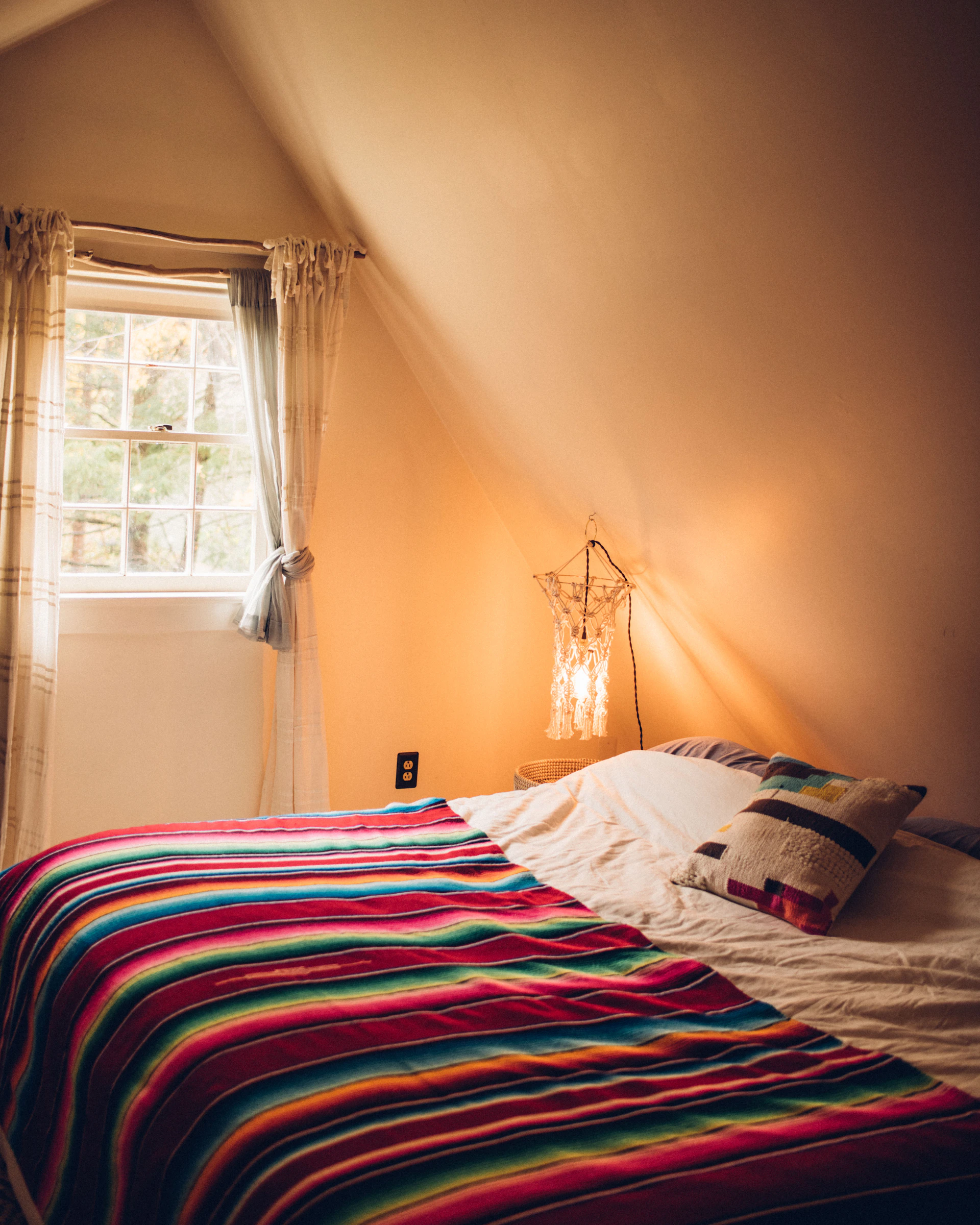 A cozy corner of the bedroom with a stylish false ceiling design and integrated lighting that casts a gentle glow over the plush bedding.
