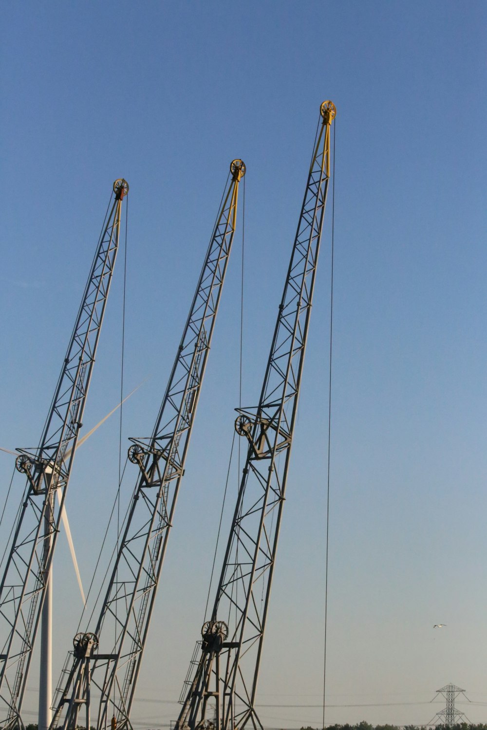 three gray metal cranes