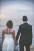 Couple walking hand in hand along the ship’s promenade, framed by the deep black sea and sky.