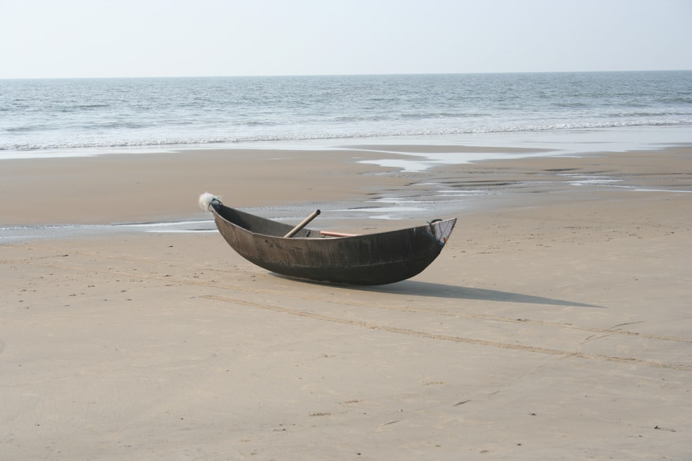 brown wooden boat on seashore during daytime