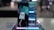A smartphone is displayed on a stand, showcasing its sleek design. Behind it, a reflective surface enhances its modern look. The device's screen features a stylized graphic, and a stylus is placed to the side.