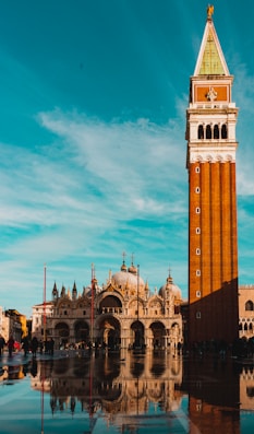 torre marrom e branca ao lado de imponente basílica