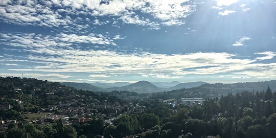 trees and houses under white clouds and blue sky in 43000 Aiguilhe France