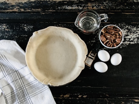 empty white plate beside three eggs