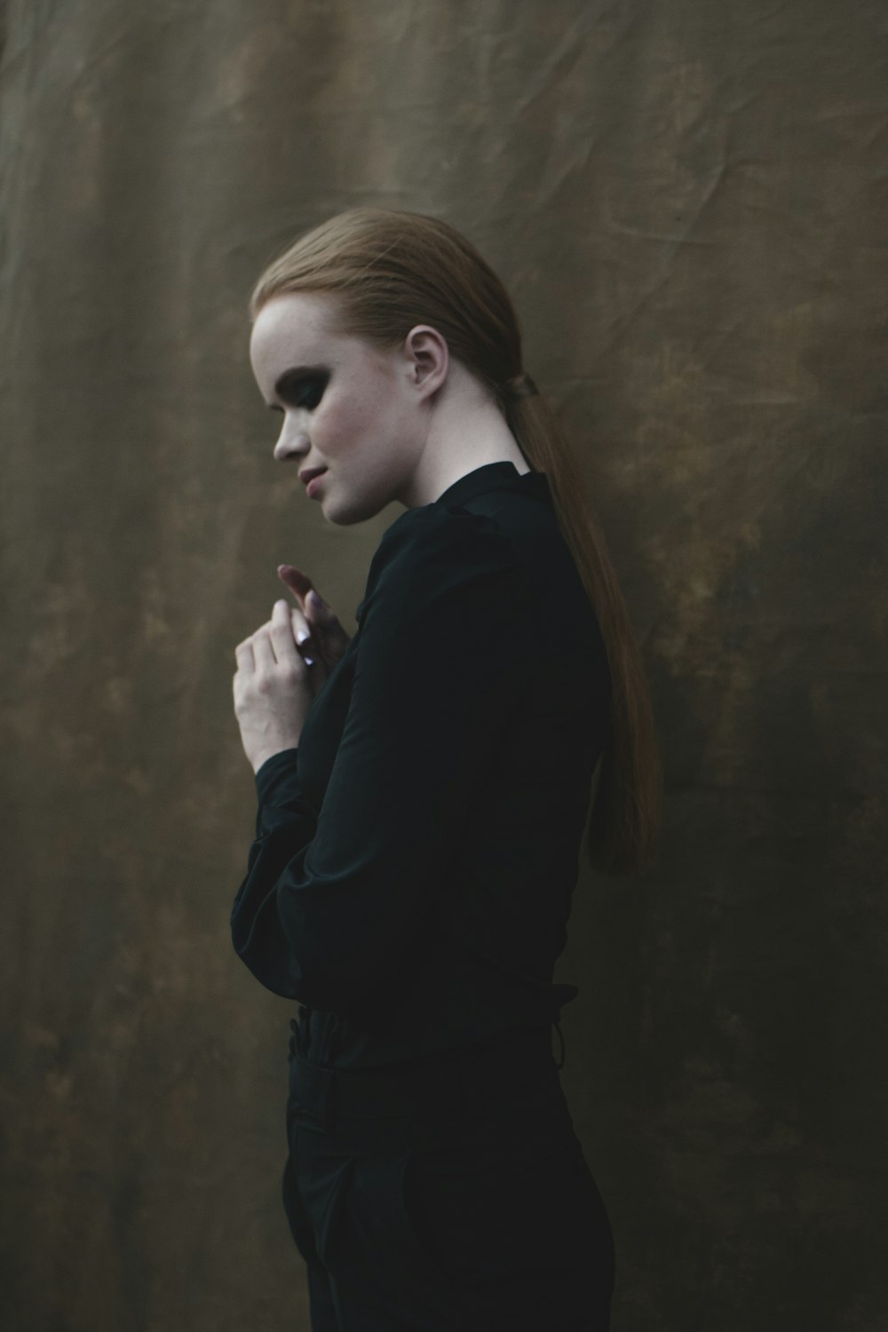 a woman with red hair wearing a black dress