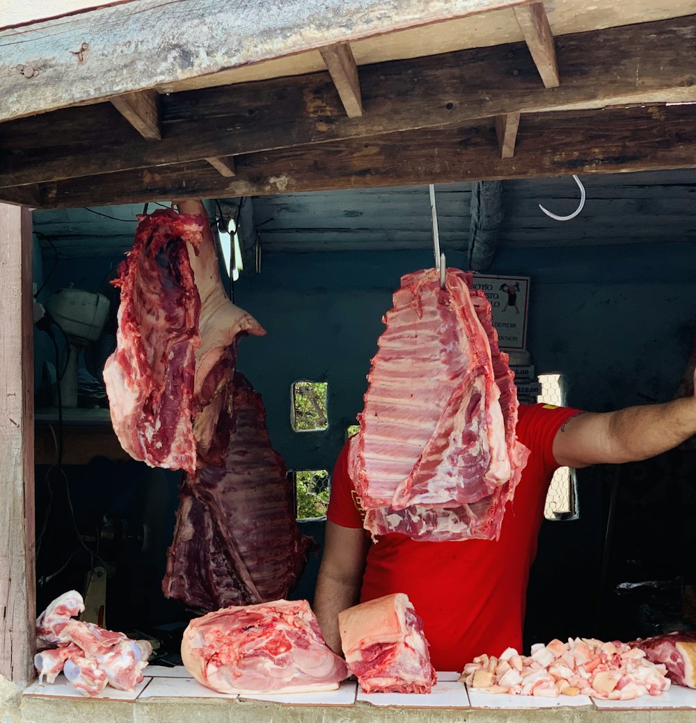 man standing in front of hanged meat