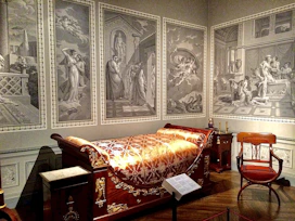 Elegant suite room with a king-sized bed and traditional artwork on the walls.