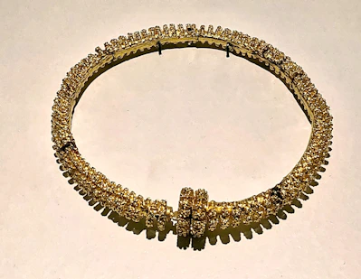 Close-up of an elegant gold necklace with intricate designs sparkling under soft light