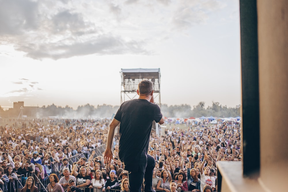 man standing on stage in front of crowd of people