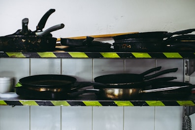 Colorful frying pans stacked neatly in a cozy kitchen setting.