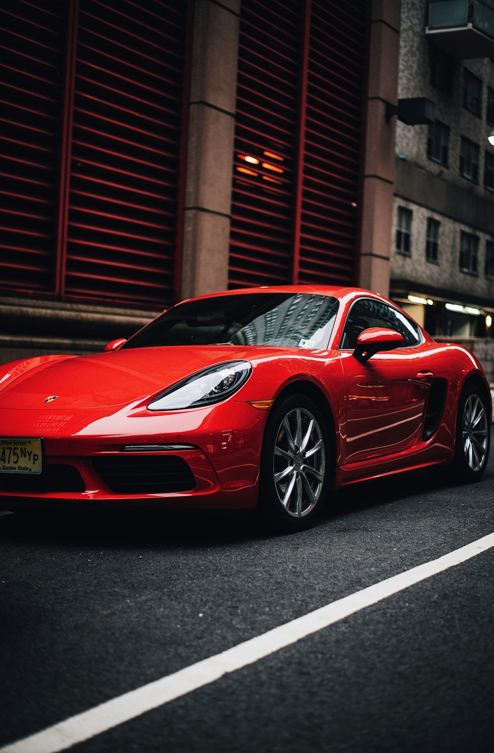 red coupe parked on concrete street