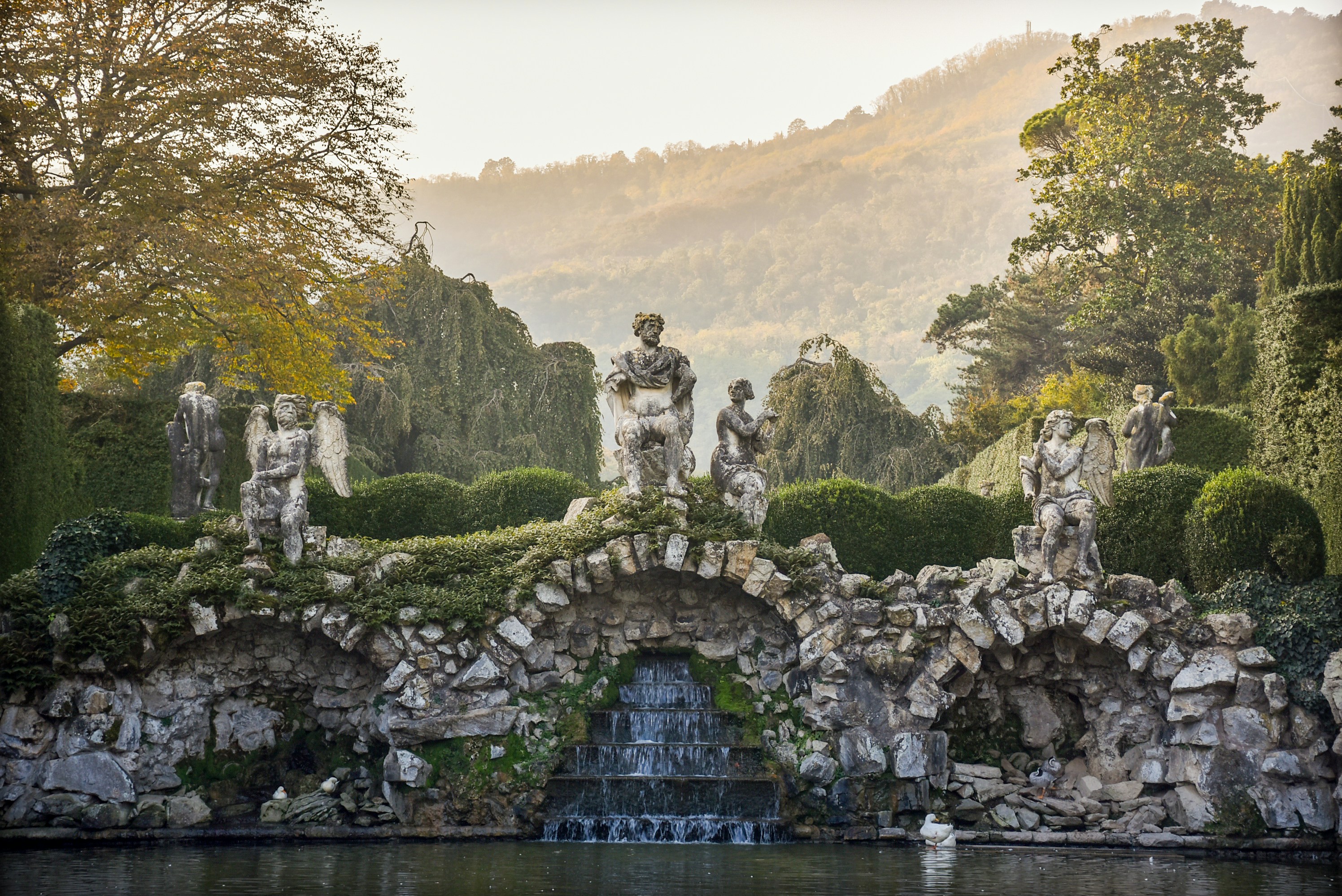 statues beside body of water during daytime