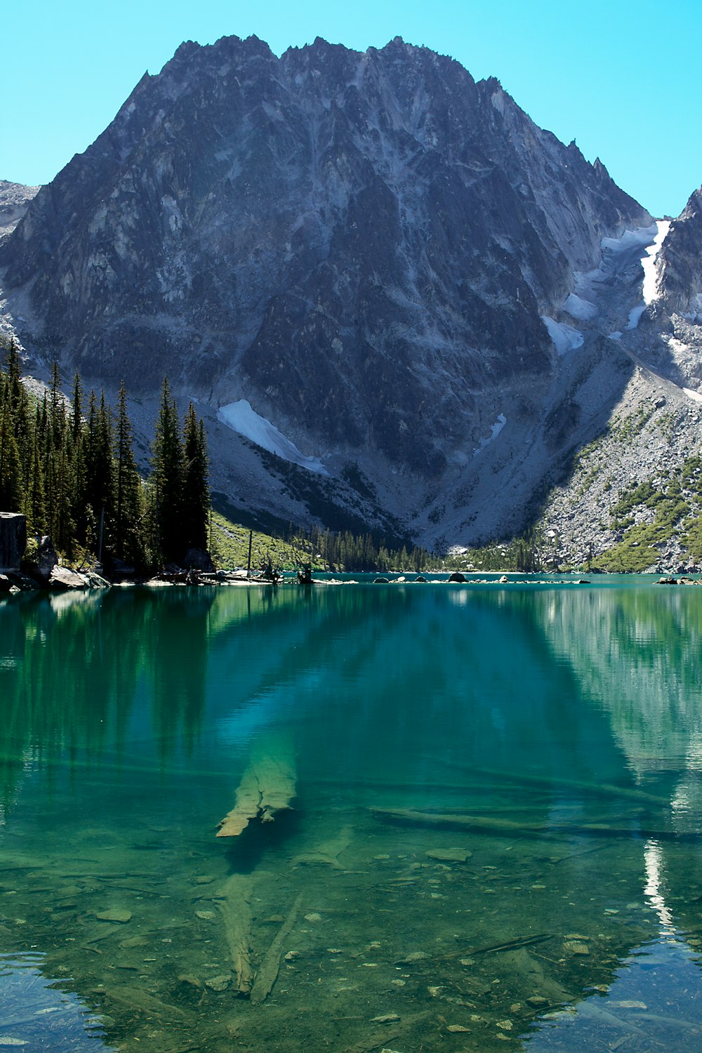 calm body of water overlooking snow capped mountains