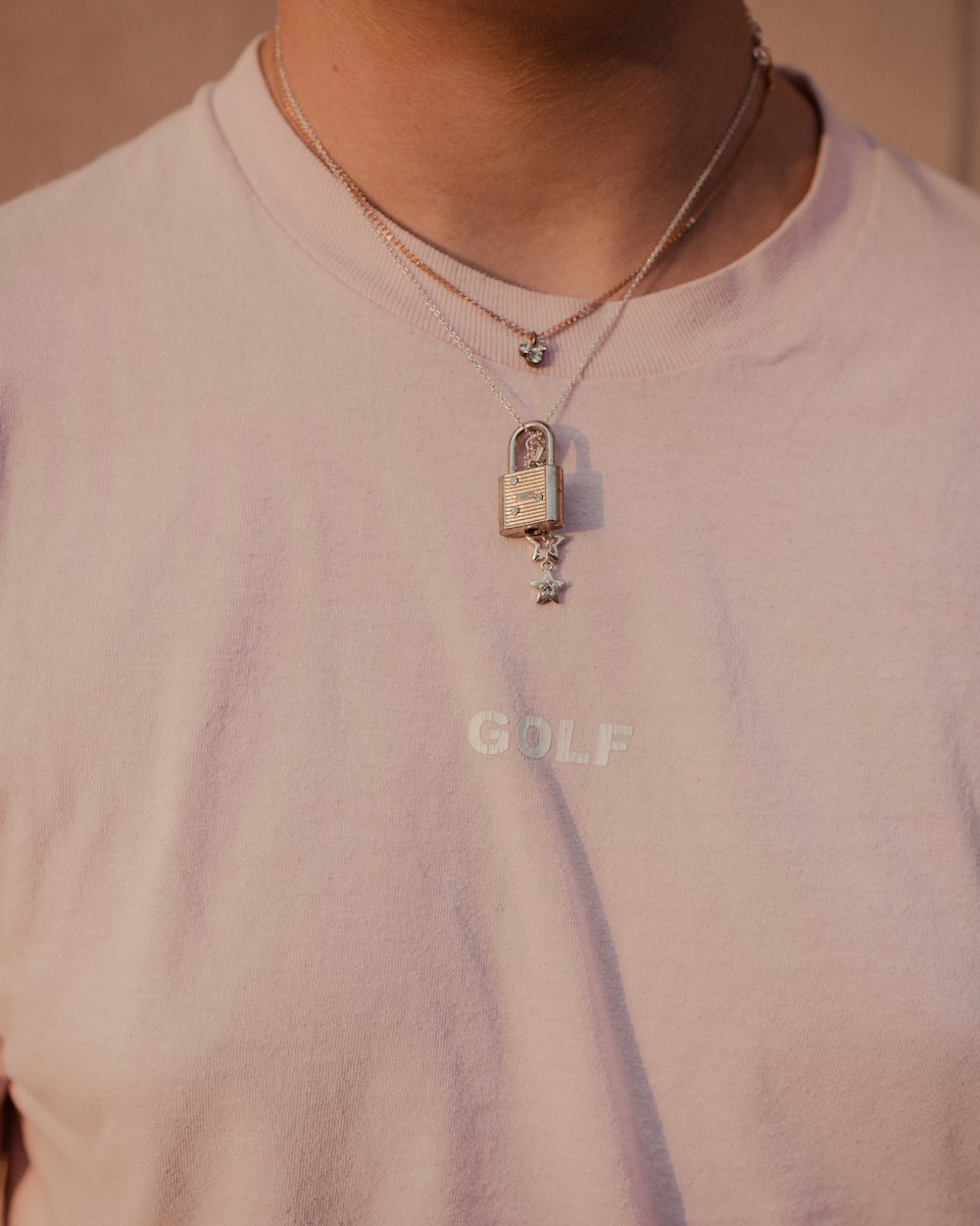 person wearing silver-colored necklace and white crew-neck top