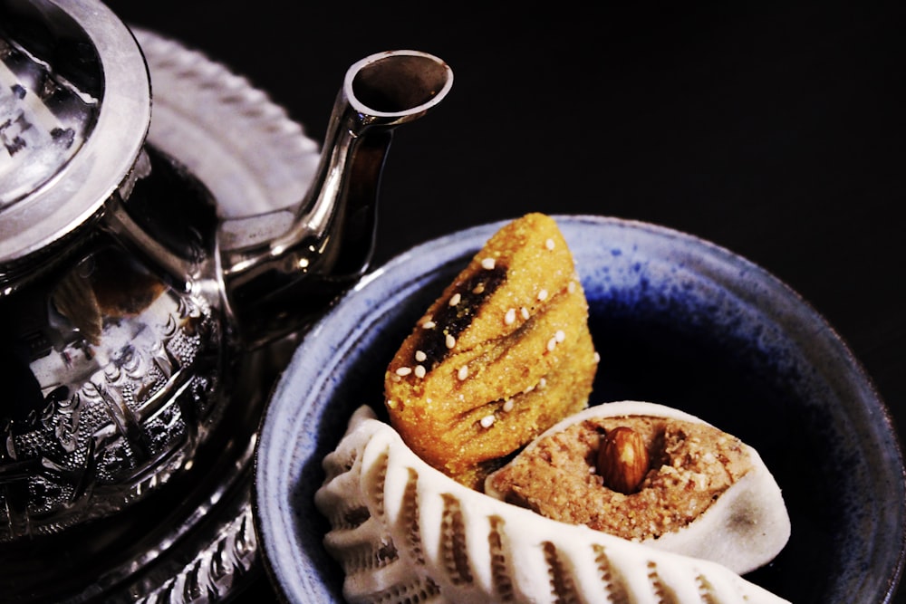 pastries on bowl beside teapot